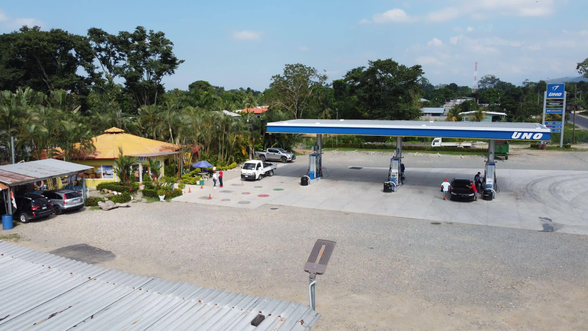 Gasolinera y tienda iluminadas al atardecer sobre la carretera en Esparta, Atlántida